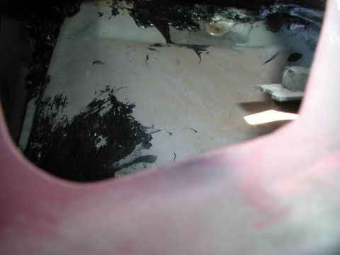 1990 Ford F-250 - Inside view of a vehicle's interior, showing a dirty, possibly rusted metal surface with black tar-like material splattered on it. A bolt a…