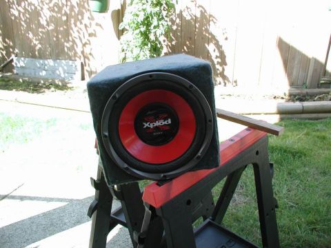 1990 Ford F-250 - A black subwoofer with a red cone is sitting on a red and black sawhorse outdoors. The subwoofer has the "Xplod" and "SONY" logos visible.
