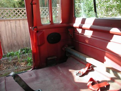 1990 Ford F-250 - Interior view of a red Ford F-250 pickup truck, showing the rear bench seat area with seatbelts and a metal bar installed across the back.…