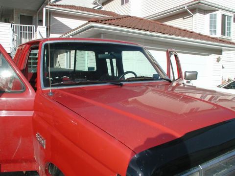 1990 Ford F-250 - The front passenger side of a red Ford F-250 pickup truck is shown with the door open. The vehicle is parked in front of a house with a gar…