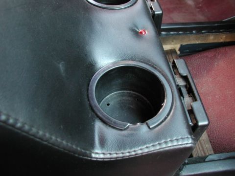 1990 Ford F-250 - A close-up view of a black vinyl center console with two cup holders and a red indicator light. The console appears to be installed in a ve…