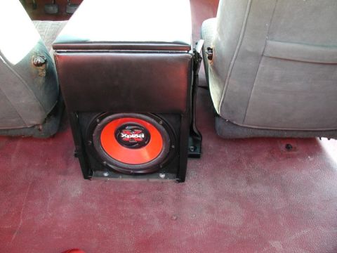 1990 Ford F-250 - A custom subwoofer box with a red and black Sony Xplod speaker is installed between the front seats of a vehicle. The interior features dar…