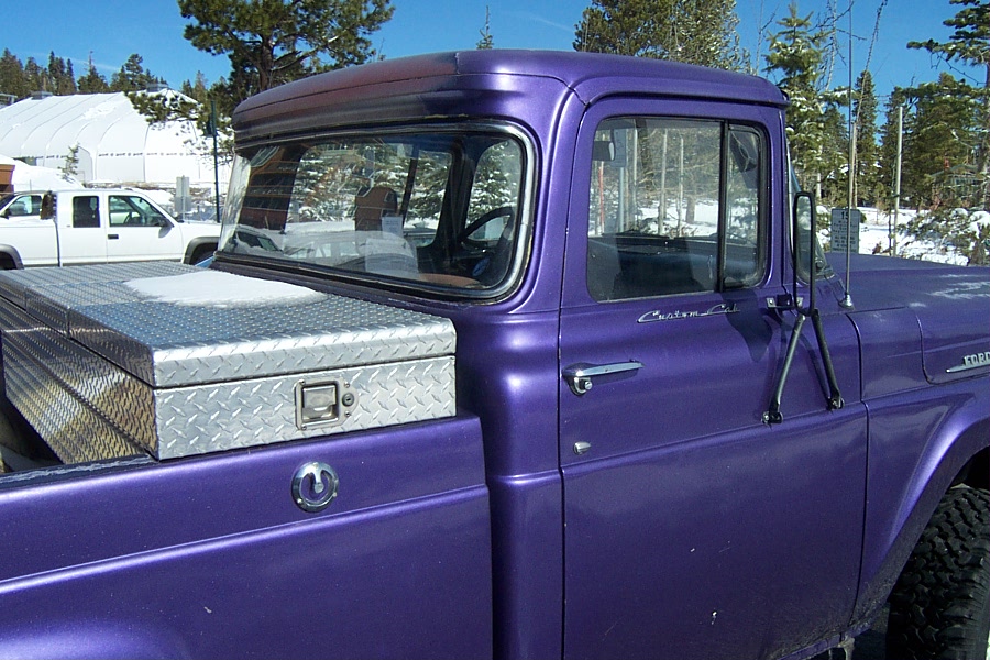 Purple pickup truck side view with diamond plate toolbox on bed. "Custom Cab" text visible on door
