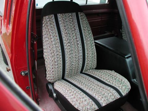 1990 Ford F-250 - The interior of a red Ford F-250 pickup truck shows a patterned fabric driver's seat with black trim and a black center console behind it.…