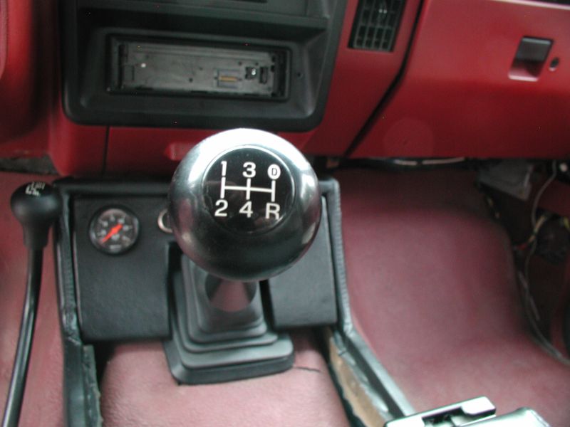 Interior view of a manual transmission vehicle with chrome shift knob and 4WD lever.