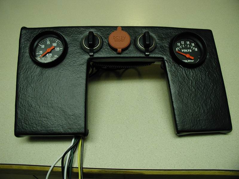 Custom dashboard panel with gauges, 12V socket, and switches.