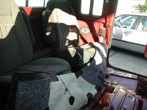 1990 Ford F-250 - The interior of a pickup truck is shown with the passenger and driver seats visible. The floor of the truck has been partially disassembled…