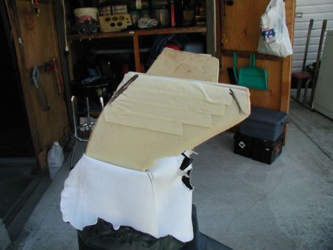 1990 Ford F-250 - A close-up view of a custom foam seat padding covered in white fabric, taped and secured with dark brown material. The padding appears to b…