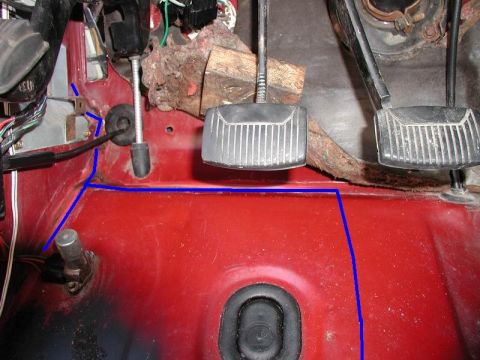 1990 Ford F-250 - The interior firewall of a red vehicle shows the clutch and brake pedals, along with wiring and a rubber grommet. A blue line traces a path…
