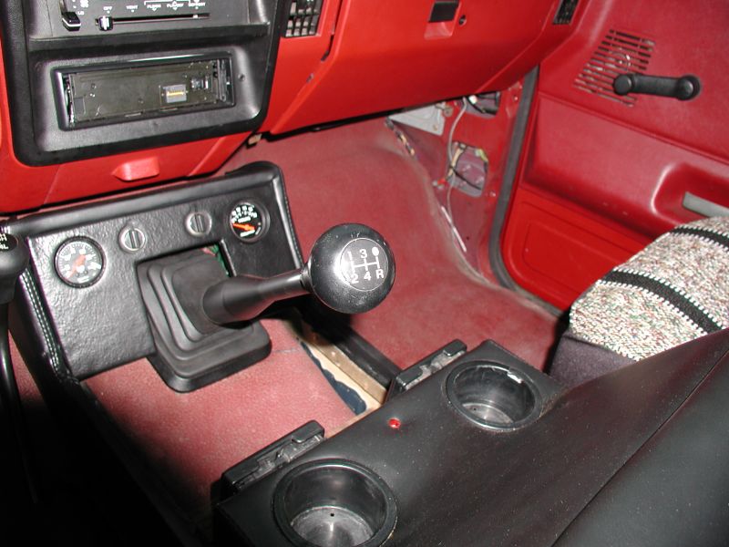 Interior view of a 1990 Ford F-250 center console with manual shifters and gauges.