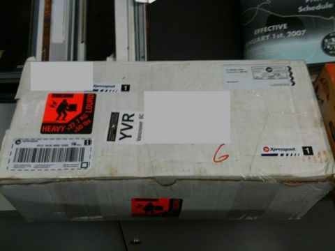 1990 Ford F-250 - A cardboard box with shipping labels and hazard stickers is shown.