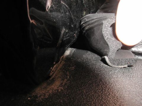 1990 Ford F-250 - A close-up view shows a black rubber seal with foam backing that appears to be damaged or detached from a vehicle's interior. Dust and debr…