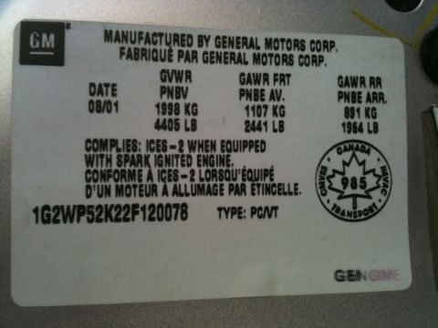2002 Pontiac Grand Prix - A close-up shot of a white sticker with black text, likely a vehicle identification or compliance plate, featuring the GM logo and various…