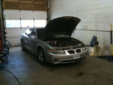 2002 Pontiac Grand Prix - A silver Pontiac Grand Prix with its hood open is parked inside a garage. The car is facing forward, and the garage door is visible in the…