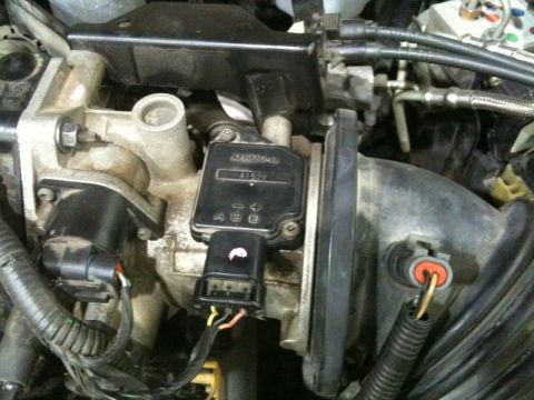 2002 Pontiac Grand Prix - This is a close-up view of the engine bay of a 2002 Pontiac Grand Prix, focusing on the throttle body and mass airflow sensor.
