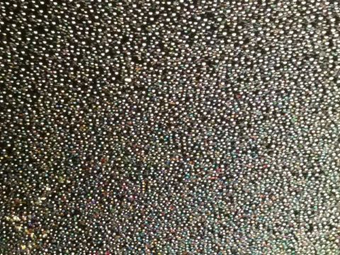 2002 Pontiac Grand Prix - A close-up shot of a black fabric with a glittery, speckled pattern. The pattern consists of numerous small, circular dots that reflect lig…