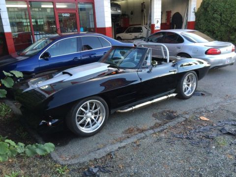 2002 Pontiac Grand Prix - A black convertible Corvette with a silver hood scoop and side pipes is parked next to a blue sedan and a silver sedan. The Corvette has cu…