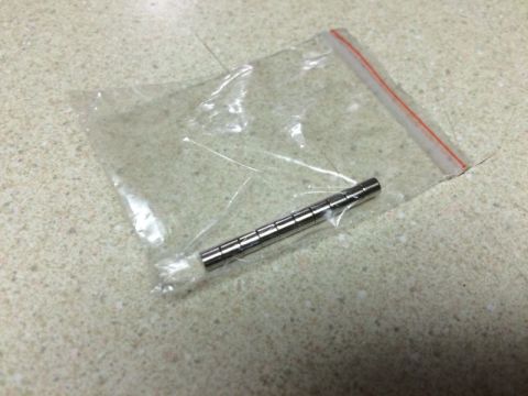 2002 Pontiac Grand Prix - A small stack of cylindrical magnets are inside a clear plastic bag with a red zipper closure. The bag is resting on a speckled countertop.