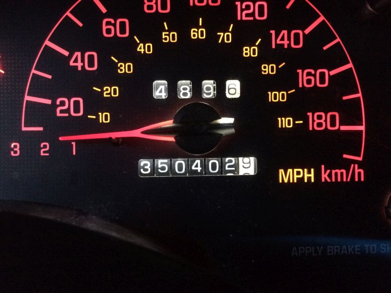 Car dashboard speedometer and odometer showing 3504029 miles.