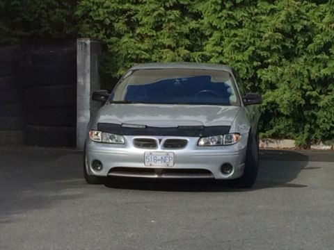 2002 Pontiac Grand Prix - Front view of a silver 2002 Pontiac Grand Prix with a black bug deflector parked in front of a hedge.