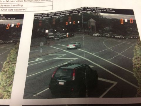 2002 Pontiac Grand Prix - A black SUV is captured in motion at an intersection, with a traffic camera document overlay showing vehicle details and a red light violat…