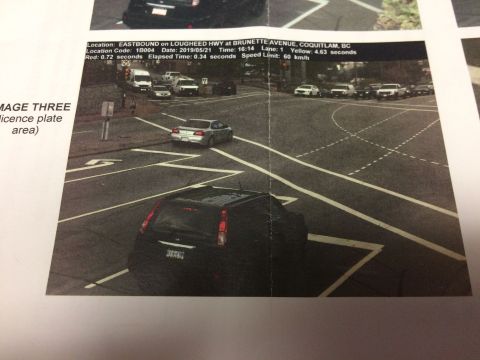 2002 Pontiac Grand Prix - A black SUV is captured from the rear at an intersection, with a red light camera ticket visible in the foreground. The ticket details the…