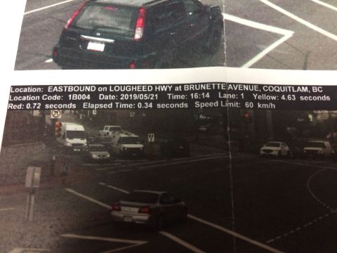 2002 Pontiac Grand Prix - A black SUV is captured from the rear, parked on a road with white lane markings. A document with traffic camera information is overlaid on…