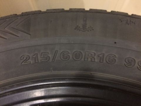 2002 Pontiac Grand Prix - A close-up of a tire shows the sidewall with the tire size "215/60R16 99". A snowflake symbol is visible above the tire size.