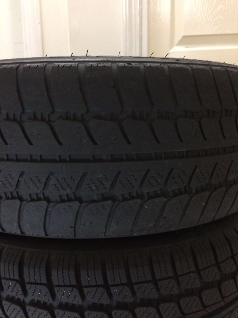 2002 Pontiac Grand Prix - A close-up view shows the tread pattern of two stacked tires. The tires have a symmetrical tread design with multiple grooves and sipes.