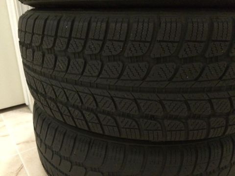 2002 Pontiac Grand Prix - A stack of four black tires with a detailed tread pattern is shown, likely for a car.