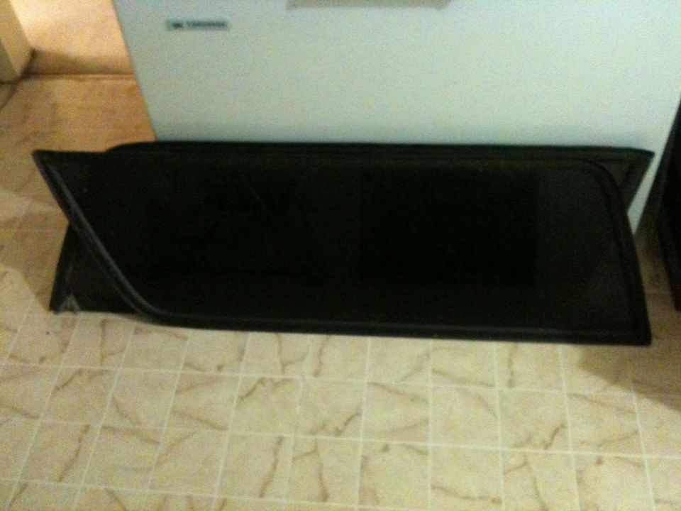 Two black car window tint panels on a tiled floor.