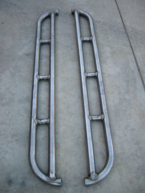 1985 Ford Bronco - Two custom-made metal rock sliders are shown laid out on a concrete floor.