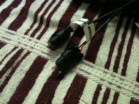 2002 Pontiac Grand Prix - Two black electrical connectors with wiring are shown on a striped towel. One connector has a white label that reads "HIGH BEAM".