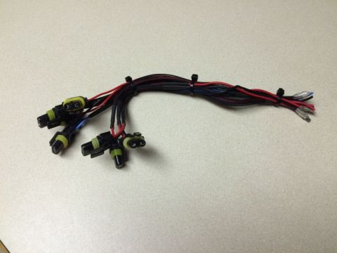2002 Pontiac Grand Prix - A bundle of wiring harnesses with multiple connectors is laid out on a speckled countertop. The harnesses are black and red, with black zip…