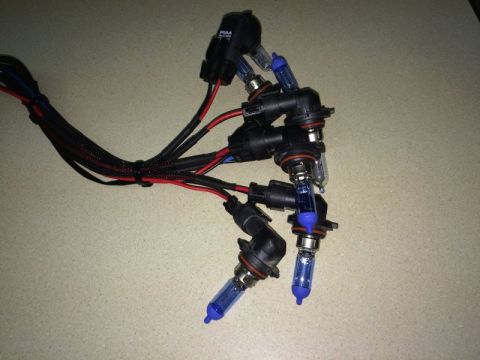 2002 Pontiac Grand Prix - A set of four PIAA brand HID bulbs with wiring harnesses are laid out on a speckled surface. The bulbs have blue-tinted glass and are conne…