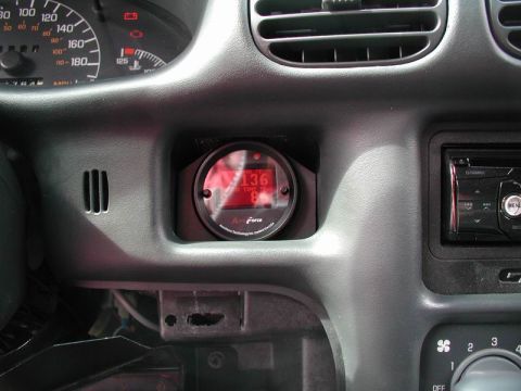 2002 Pontiac Grand Prix - A close-up view of a car's dashboard shows a digital gauge displaying "136" and "TRANS TEMP". To the right, a car stereo is visible.
