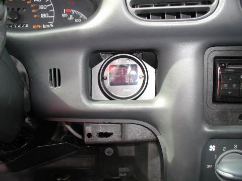 2002 Pontiac Grand Prix - The interior of a car shows a custom gauge installed in the dashboard, next to the car's stereo. The gauge displays temperature and other r…