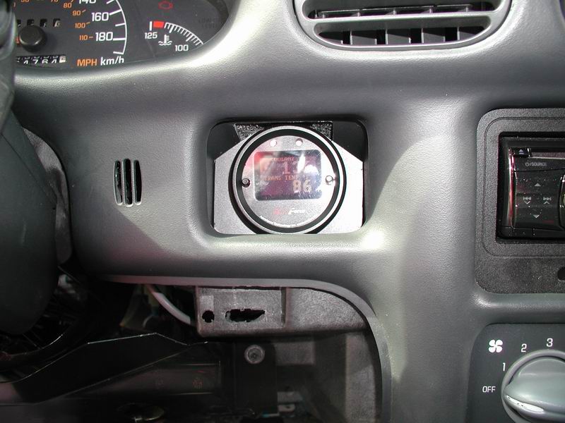 Close-up of a car dashboard with a custom digital gauge installed.