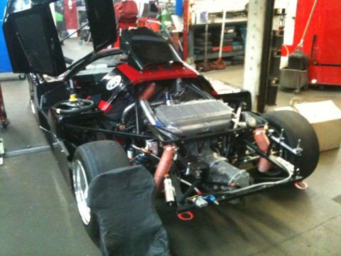 2002 Pontiac Grand Prix - The rear of a black custom or race car is shown with its engine and suspension components exposed. The car has gullwing doors open upwards…
