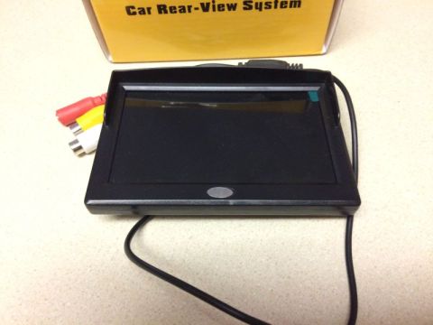 2002 Pontiac Grand Prix - A car rear-view system is shown, including a small black screen with RCA input cables and a power cord. The system is partially in front of…