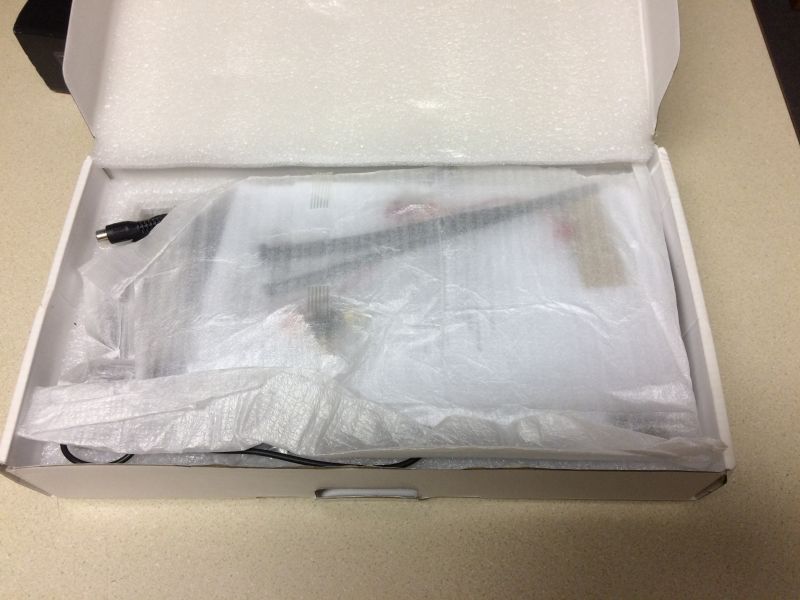 White box with electronics inside, wrapped in plastic and foam.