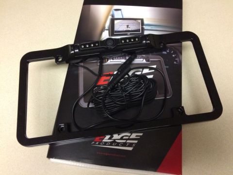 2002 Pontiac Grand Prix - A black license plate frame with an integrated backup camera and wiring is displayed on top of a product brochure for Edge Products.