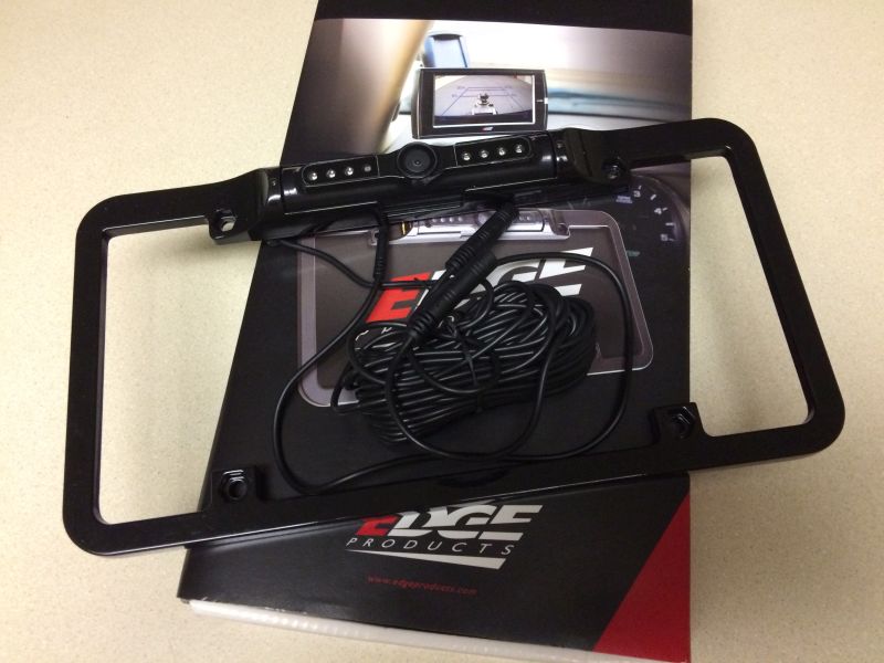 Black license plate frame with backup camera and wiring on Edge Products brochure