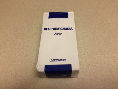 2002 Pontiac Grand Prix - A white box with blue accents is shown. Text on the box reads "REAR VIEW CAMERA WR01" and "AZDOME".