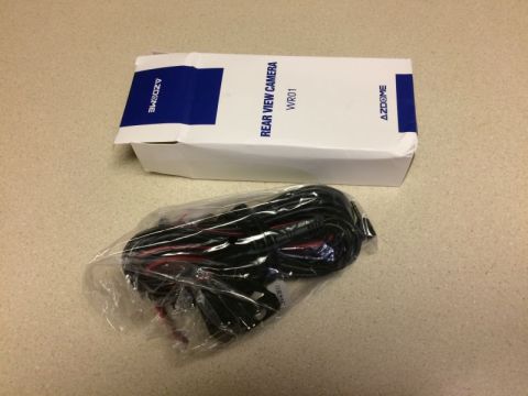 2002 Pontiac Grand Prix - A white box with blue accents is open, revealing a coiled black wire harness inside a plastic bag. Text on the box reads "AZDOME REAR VIEW…