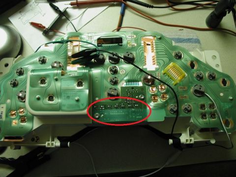 2002 Pontiac Grand Prix - The back of a green circuit board, likely from a car's instrument cluster, is shown with various components and wiring. A red circle highli…