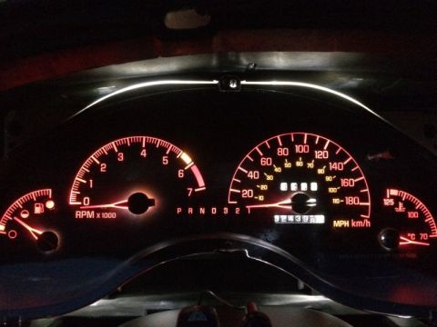 2002 Pontiac Grand Prix - The illuminated dashboard of a 2002 Pontiac Grand Prix at night shows a tachometer reading just under 1000 RPM, a speedometer reading appro…