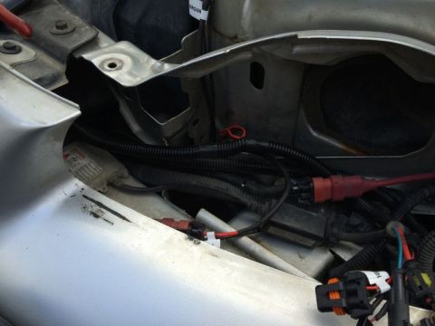 2002 Pontiac Grand Prix - Close-up view of wiring harnesses and connectors under the hood of a car, possibly a 2002 Pontiac Grand Prix, with a silver fender visible…