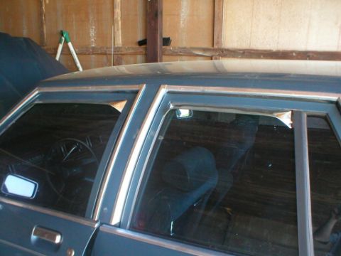 1987 Ford Crown Victoria LTD - The interior of a car is visible, including the steering wheel and dashboard through the side window.