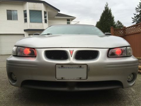 2002 Pontiac Grand Prix - Front view of a silver Pontiac Grand Prix with red halo headlights. The car has a black honeycomb grille and a "Beautiful British Columbia"…